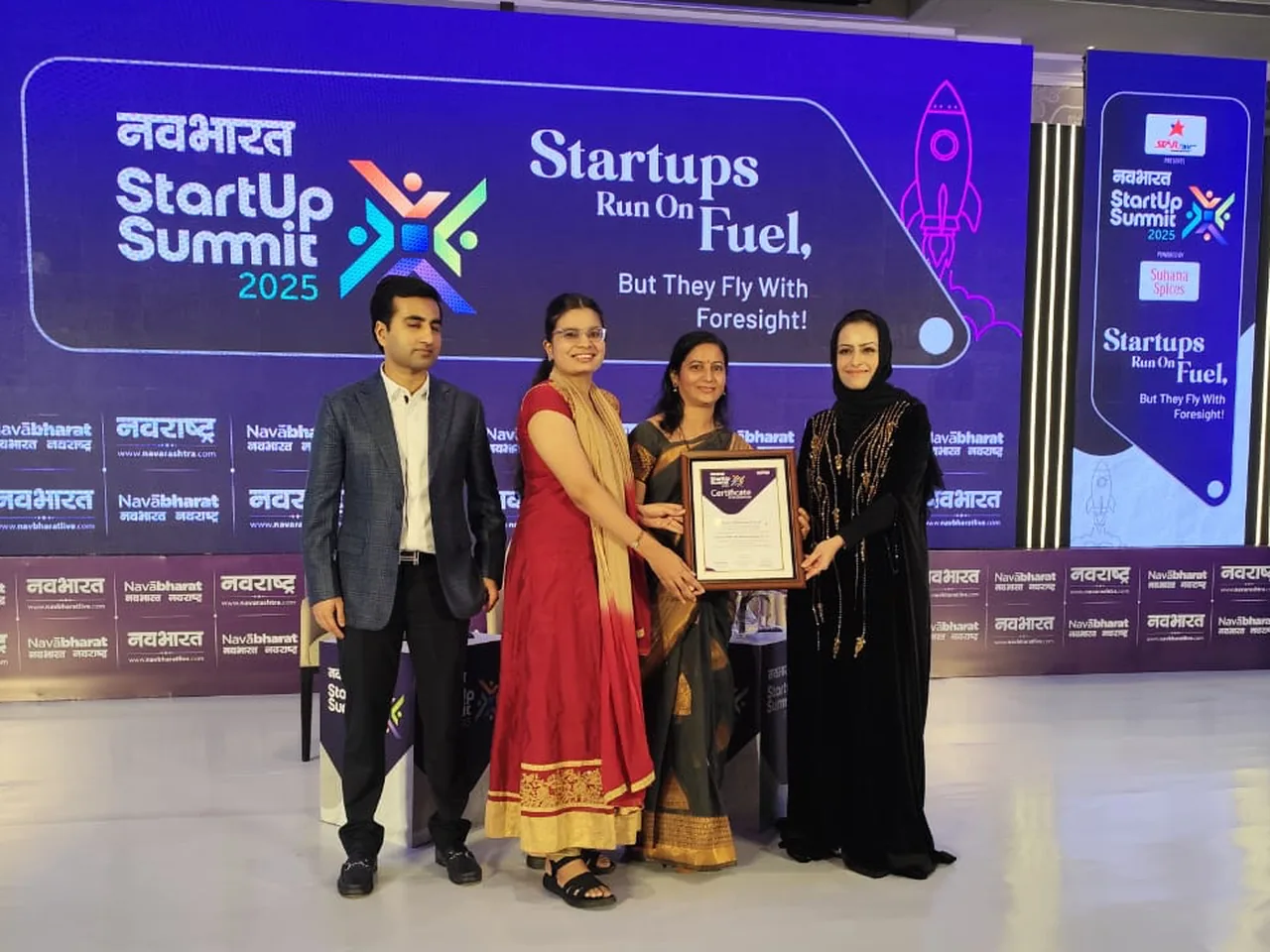 Founders receiving the Navbharat Samachar Award certificate on stage at the Navbharat StartUp Summit 2025